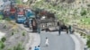 People look at a charred vehicle near a collapsed railway bridge a day after a blast by separatist Baloch Liberation Army militants at Kolpur in Bolan district, Balochistan Province, on August 27.