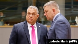 Hungarian Prime Minister Viktor Orban (left) speaks with his Slovakian counterpart Robert Fico prior to the start of a EU leaders summit in Brussels. (file photo)