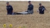 Ukrainian rescue workers carry the body of one of the 298 victims on a stretcher through a wheat field at the site of the MH17 crash on July 19, 2014.