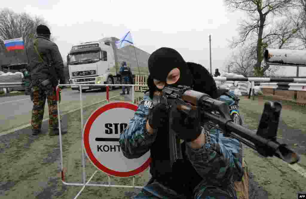 Между материковой Украиной и полуостровом были выставленны блокпосты. Бывший сотрудник Беркута вооруженный автоматом Калашникова стоит неподалеку от города Армянск.28 февраля 2014 года.